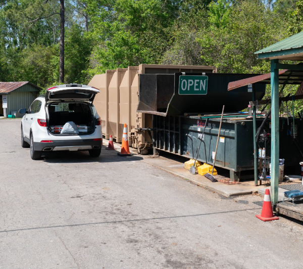 Image of Customer cat alongside trash compactor.